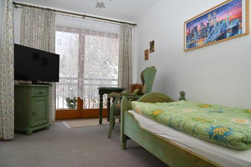 a bedroom with a bed and a flat screen tv at Pension Klein in Bodenmais