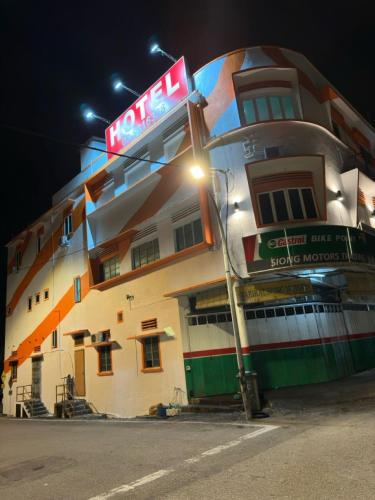 a hotel building with a neon sign in front of it at Orange Hotel Segamat in Segamat