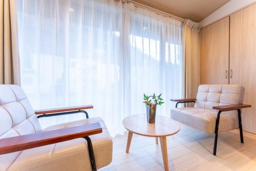 a living room with a couch and a chair and a table at Stagione Hakone Yumoto Villa スタジオーネ箱根湯本VILLA in Hakone