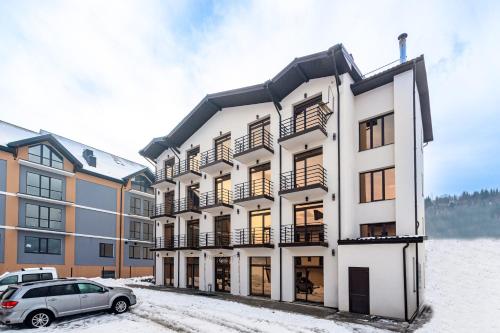 a building with a car parked in front of it at GARDA - Breakfast included in the price Restaurant Free Parking Mountain view Kitchen in the apartment separate entrance in Bukovel