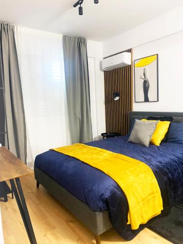 um quarto com uma cama com um cobertor azul e amarelo em Luxury City Retreat- 2-Bedroom, 2-Bath Apartment em Nicósia