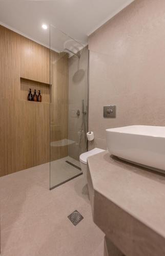 a bathroom with a sink and a toilet and a tub at Apollo Luxury Suites in Preveza
