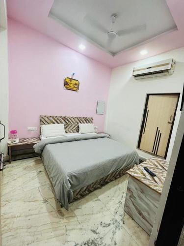 a bedroom with a large bed and pink walls at HOTEL S S PALACE in Agra