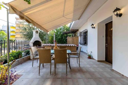 a patio with a table and chairs and a fireplace at Nagias cozy garden home in Athens