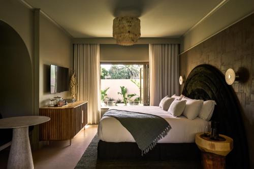 Swell Hotel Byron Bay - Adults Only في خليج بايرون: غرفة نوم بسرير كبير ونافذة