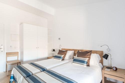 a bedroom with a bed with white sheets and pillows at Bordoy Mostatxins - Hotel Boutique Adults Only in Alcudia