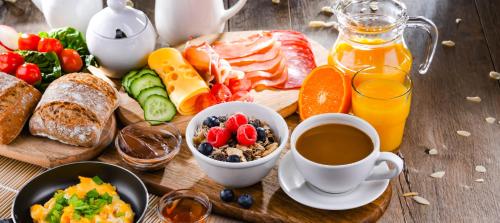 een tafel met ontbijtproducten en een kopje koffie bij Pensjonat nad Jeziorem in Powidz