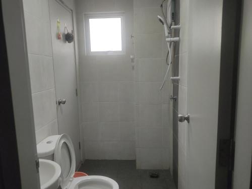 biała łazienka z toaletą i umywalką w obiekcie Hulu Yam Musliim Homestay w mieście Batang Kali