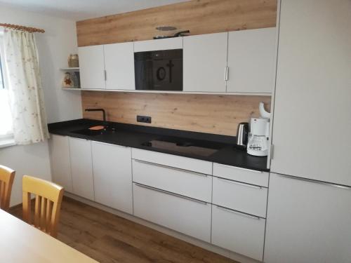 a kitchen with white cabinets and a black counter top at Ferienhaus Kirchler in Hippach