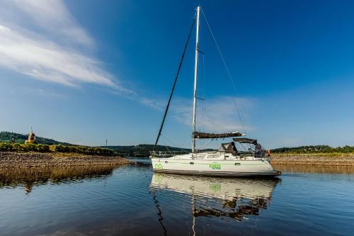 a sailboat is docked on the water at KORZO LIPNO C in Lipno nad Vltavou