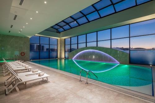 een zwembad met grote glazen wanden bij Doubletree by Hilton Istanbul Umraniye in Istanbul