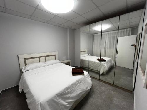 1 dormitorio con 1 cama blanca grande y espejo en RMN TOURIST HOME, en Valencia