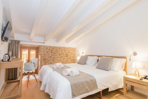 a bedroom with a large bed with towels on it at Bordoy Mostatxins - Hotel Boutique Adults Only in Alcudia