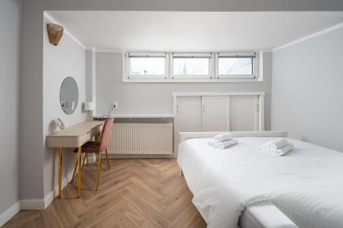 a white bedroom with two beds and a desk at Nowy Świat 22 Luxury Apartment in Warsaw