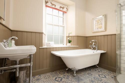 a bathroom with a tub and a sink at Birch Cottage in Cockburnspath