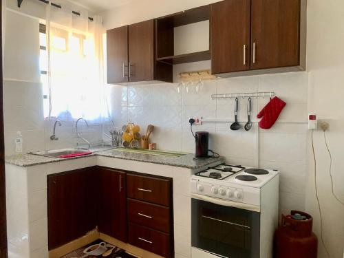 a kitchen with a white stove and a sink at Rorot 1 bedroom Kapsoya with free wifi and great views! in Eldoret