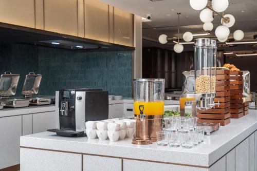a kitchen with a counter with drinks and glasses on it at Hilton Garden Inn Huzhou High-Speed Railway Station in Huzhou