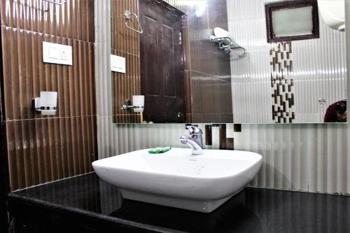 a bathroom with a sink and a mirror at Hotel Vijayant in Manāli