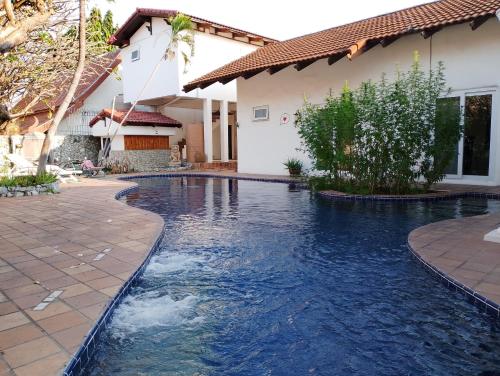 a swimming pool in front of a house at Luxury Private Pool Villa 5 min from Walking Street and Beaches in Pattaya South