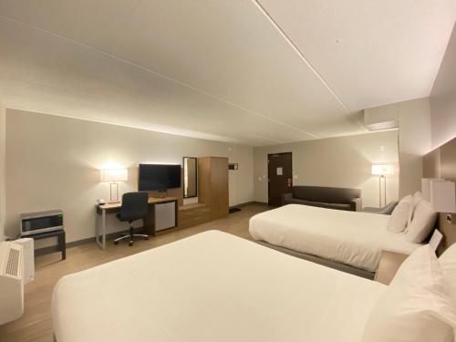 Habitación de hotel con 2 camas y TV de pantalla plana. en Superior Stay Hotel, en Marquette