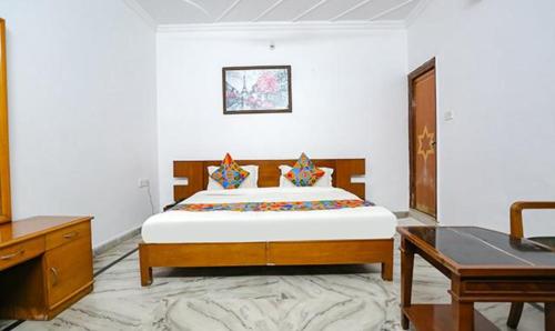 a bedroom with a large bed and a desk at FabExpress Premium Rooms in New Delhi