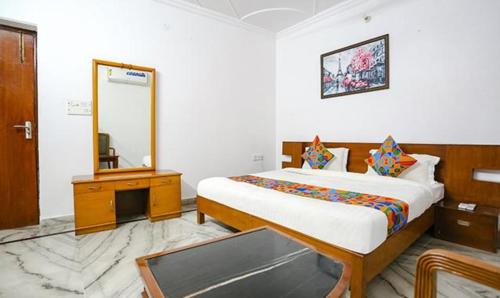 a bedroom with a large bed and a mirror at FabExpress Premium Rooms in New Delhi