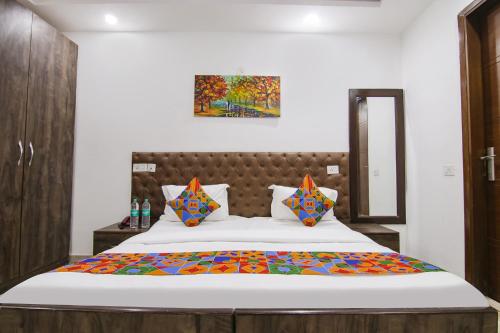 een slaapkamer met een groot bed met kleurrijke kussens bij FabExpress The Premium Villa in New Delhi