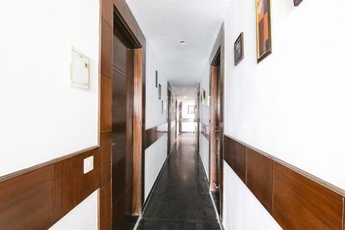 a hallway with white walls and wood paneling at Hotel The Premium Villa in New Delhi