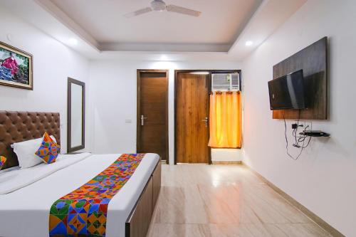 a bedroom with a bed and a tv on the wall at Hotel The Premium Villa in New Delhi