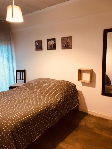 - une chambre avec un lit et des photos sur le mur dans l'établissement Le Léonie, à Hagondange