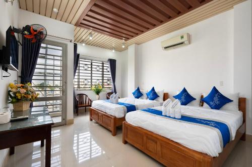 1 dormitorio con 2 camas, mesa y escritorio en Khách Sạn Lộc Phát, en Ho Chi Minh