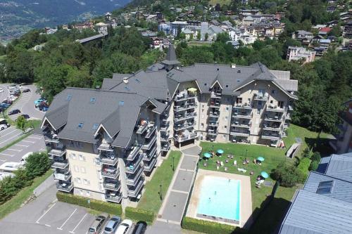 - une vue aérienne sur un grand immeuble avec piscine dans l'établissement Next to the ski lift! *3bed Apt* sleeps 8* Parking* Pool, à Saint-Gervais-les-Bains