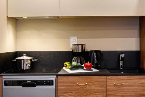 a kitchen with a stove and a counter top at Résidence Meublée Bellini Vannes in Vannes