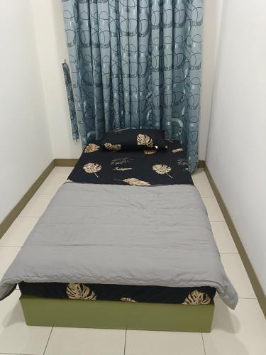 a bed in a room with a blue curtain at AISY HOMESTAY KULIM/LUNAS in Kulim