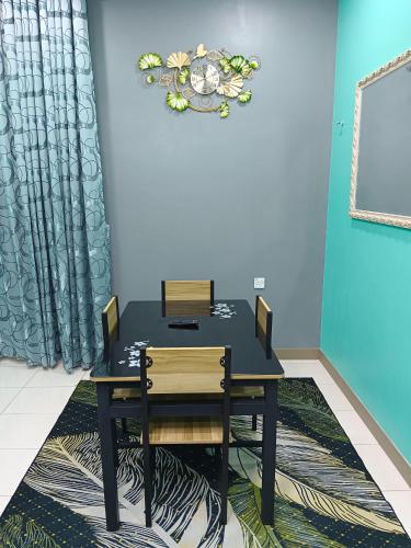 a black table and chairs in a room at AISY HOMESTAY KULIM/LUNAS in Kulim