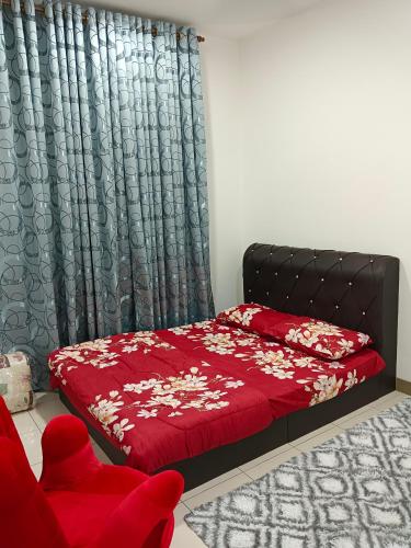 a bedroom with a red bed and a chair at AISY HOMESTAY KULIM/LUNAS in Kulim