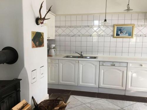 una cocina con armarios blancos y fregadero en Nice apartment in Hesse with relaxation area, 