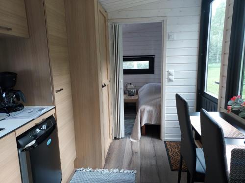 a kitchen and dining room with a table in a tiny house at Minicabin in Vuokatti