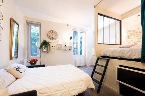 - une chambre avec 2 lits et une horloge murale dans l'établissement My Nest Inn Paris Quartier Latin - 27m2 - Rénové, à Paris