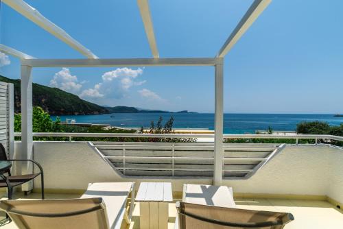 Un balcón con sillas y vistas al océano. en N. Ammos Lichnos en Párga