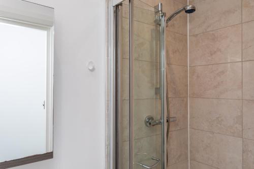 a shower with a glass door in a bathroom at Studio Flat in the Heart of Crawley- Apartment 5 in Crawley