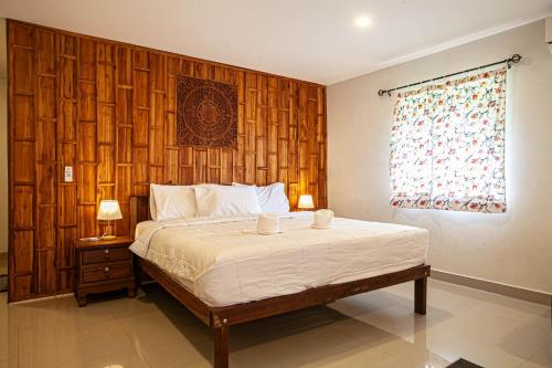 a bedroom with a bed and a wooden wall at Lanta Thai Homestay in Ko Lanta