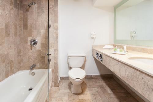 a bathroom with a toilet and a sink and a shower at Baymont by Wyndham Lazaro Cardenas in Lázaro Cárdenas