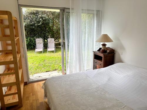 a bedroom with a bed and a window with chairs at BRUNEEL - Appartement 4 personnes Carnac in Carnac