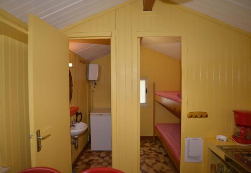 Cette petite chambre comprend 2 lits superposés et une salle de bains. dans l'établissement Camping la Rouviere les Pins, à Vagnas