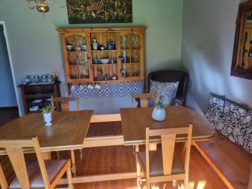 dwa stoły i krzesła w pokoju z szafką w obiekcie Angel 8 AirBnB Family Apartment w mieście Robertson