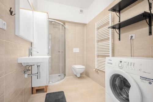 uma casa de banho com uma máquina de lavar roupa e um lavatório em Residence Štefánikova Violet em Brno