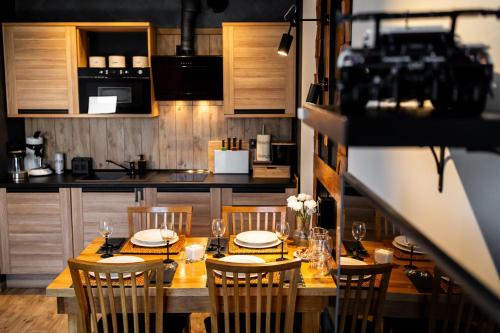 eine Küche mit einem Holztisch mit Stühlen und einem Esszimmer in der Unterkunft MAESTRIA POLANICA in Polanica-Zdrój