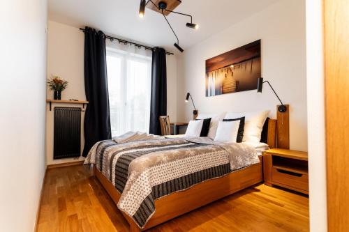um quarto com uma cama e uma janela em MAESTRIA POLANICA em Polanica-Zdrój
