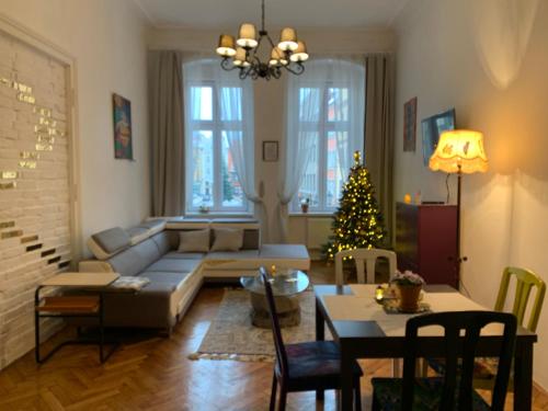 a living room with a couch and a christmas tree at RynekArt Apartment in Świdnica